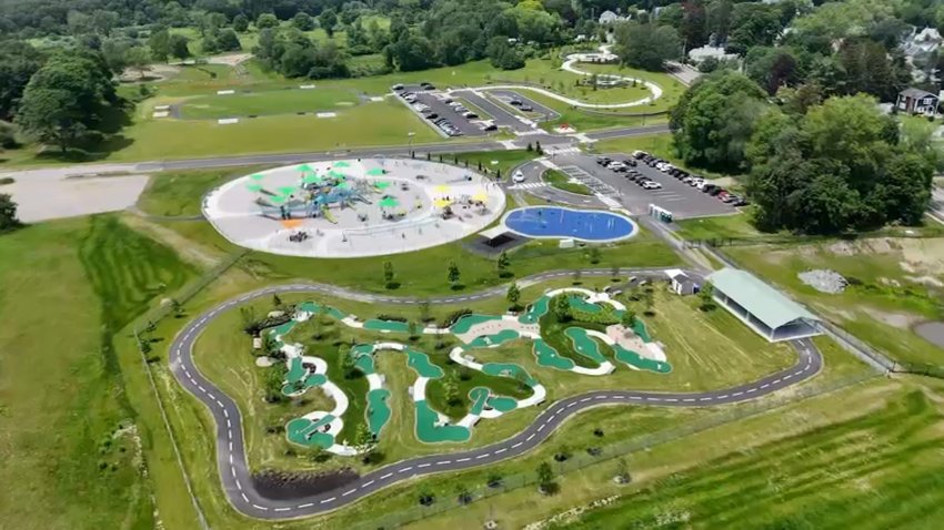 An aerial view of 200 Trapelo Park in Waltham, Massachusetts. It's large and accessible playground, mini-golf course and splash pad can be seen.