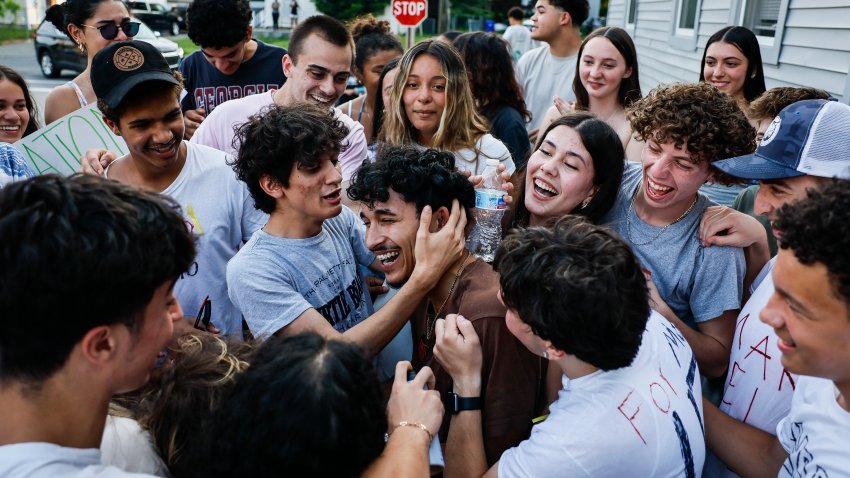 Milford, MA – June 5: Marcelo Gomes da Silva, center, is embraced by friends outside his home on June 5, 2025, after his release from ICE detention. (Photo by Erin Clark/The Boston Globe via Getty Images)