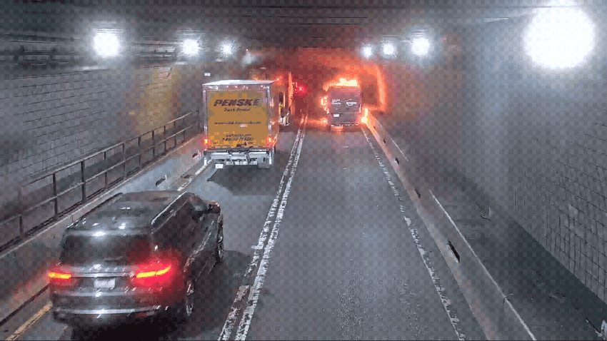 Vehicles pass an Amazon delivery van on fire in the Ted Williams Tunnel in Boston on Monday, June 23, 2025.