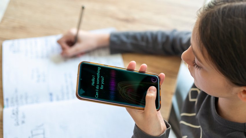 Young girl uses AI virtual assistant to do schoolwork.Concept of Artificial Intelligence and Futuristic technology
