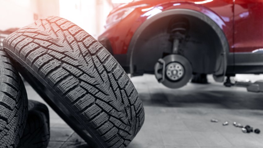 Concept car wheel service, changing winter tire on machine at station.